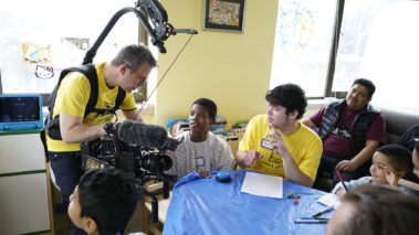 Film crew talking to pediatric patients during shoot with Project sunshine. Behind the scenes film shoot for 5-part promotional campaign to highlight the scope and impact of their work. Pediatric patients. Non profit. Production services.